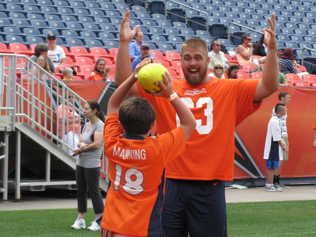 Broncos player Ben Garland makes a human goal post for an NSCD athlete. Credit.