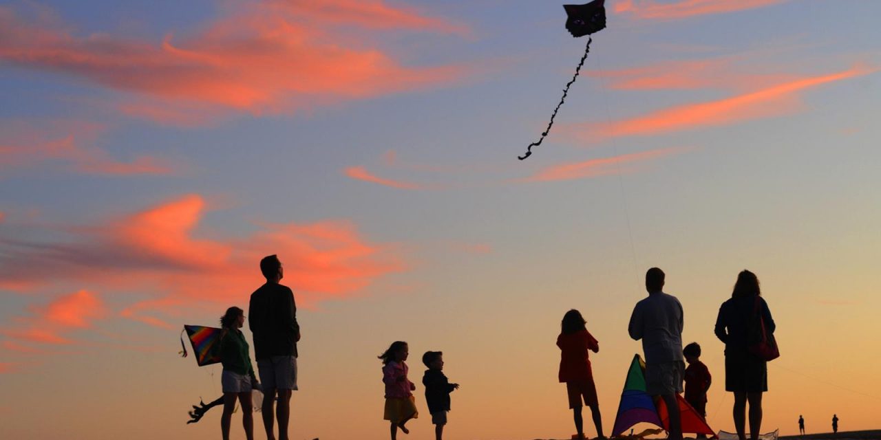 Family Flying Kites with Sunset
