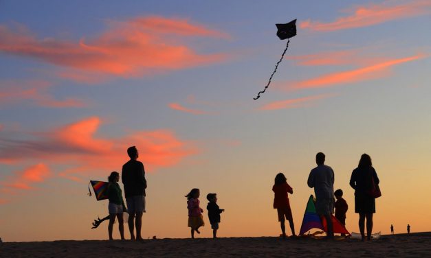 Family Flying Kites with Sunset