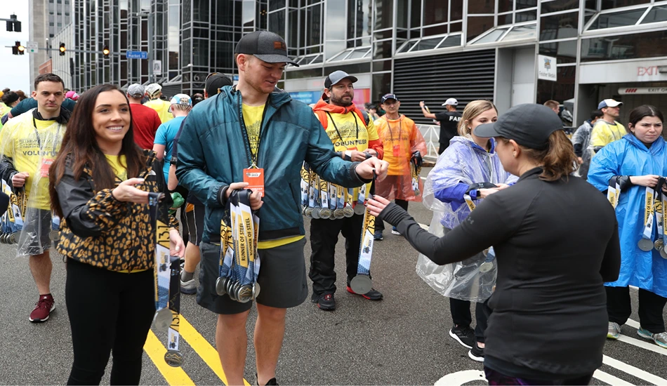 Pittsburgh Marathon volunteers handing out finisher medals. Photo courtesy of P3R.