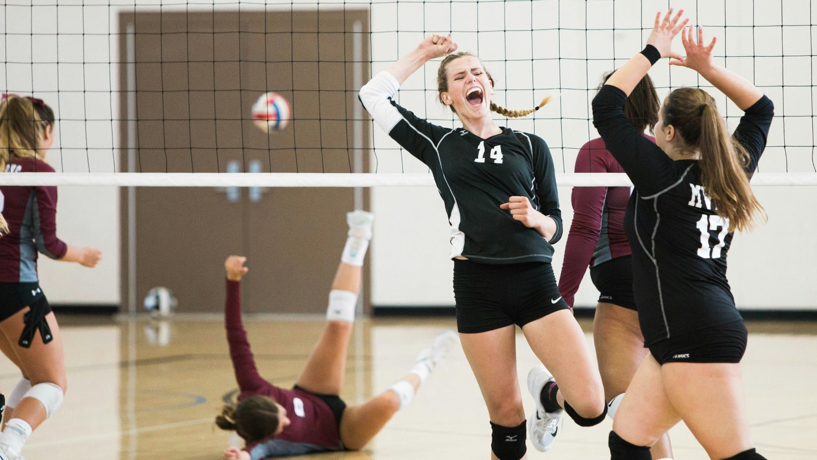 Youth volleyball players celebrate securing a set. Photo by Vince Fleming via Unsplash.